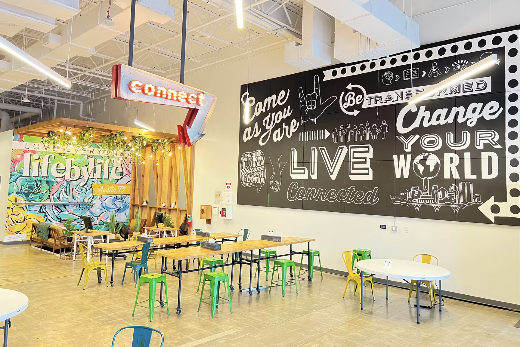 Dwell Coworking in South Austin with vibrant murals, Connect neon sign, colorful metal stools, and inspirational wall art