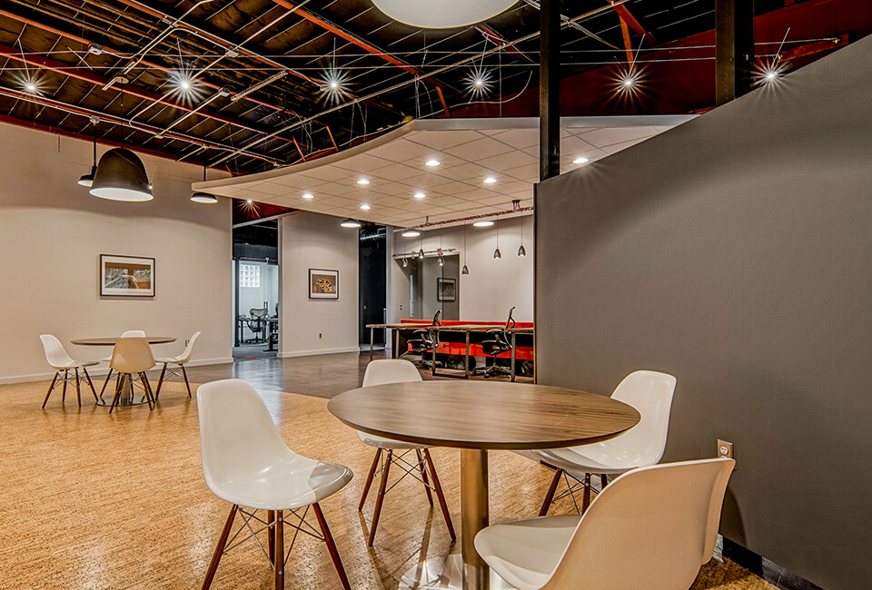 fibercove coworking space on South Lamar with industrial ceiling, round meeting tables, and gym area