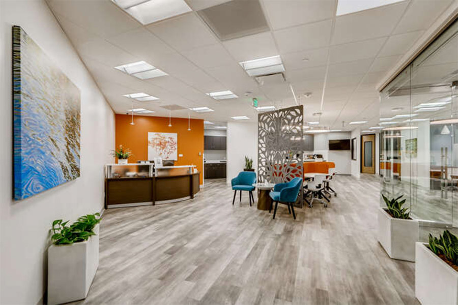 Office Evolution Austin Arboretum professional workspace with orange accent wall, reception desk and meeting area