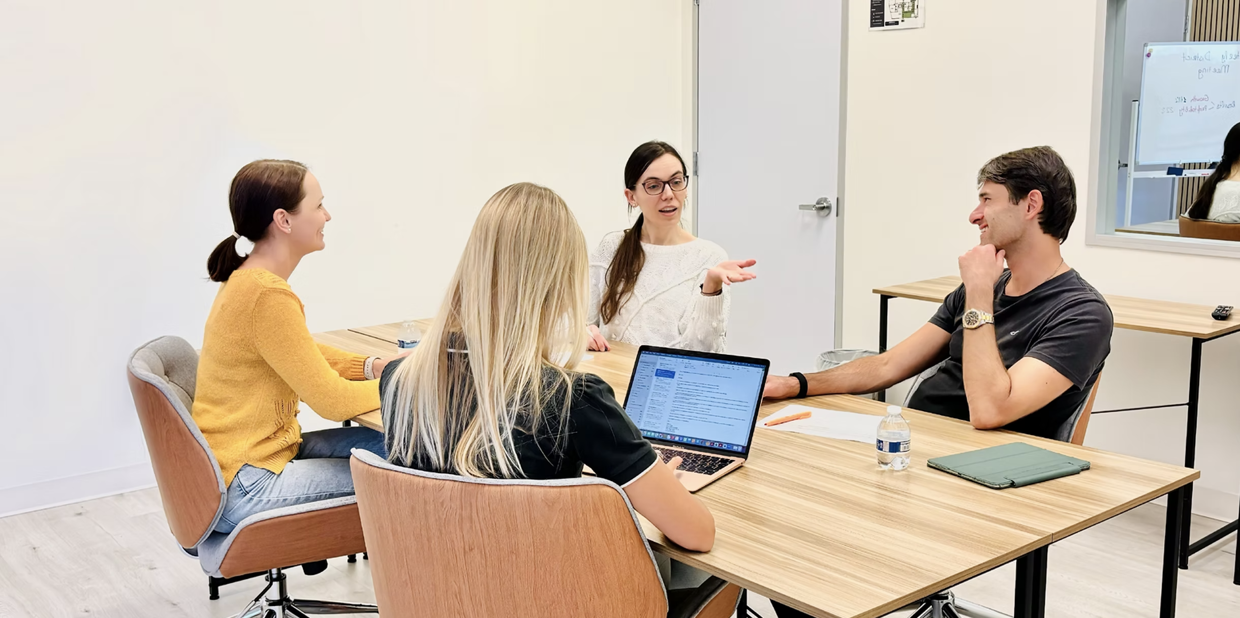WorkCastle coworking space with four professionals collaborating around a wooden meeting table